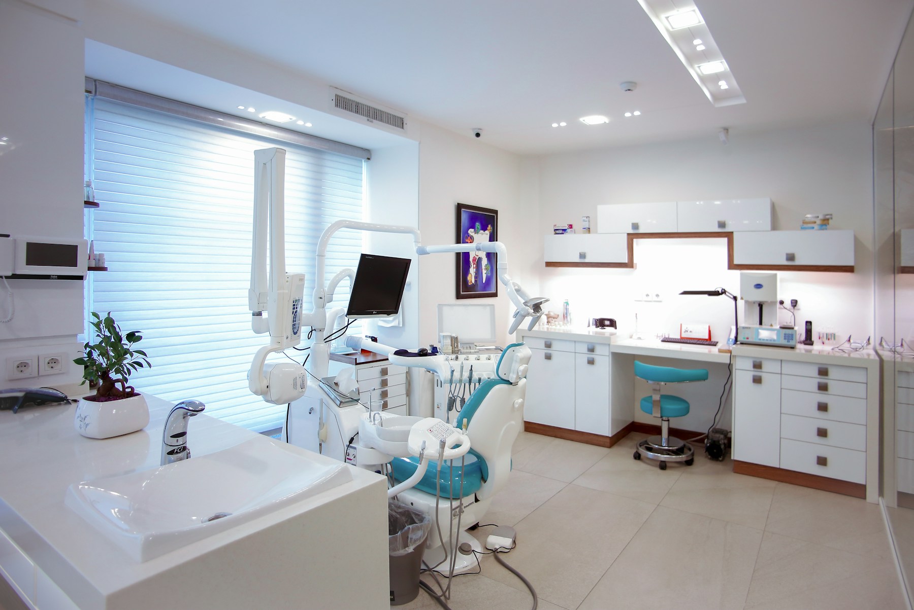 Bright dental treatment room with a dental chair and clinical equipment